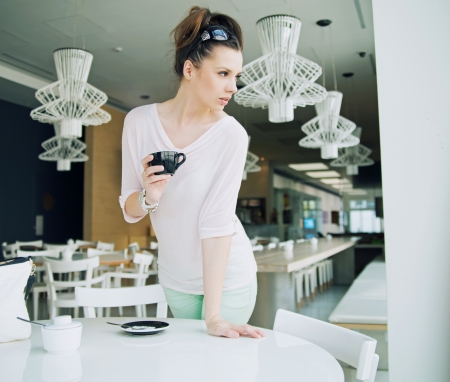 Alluring brunette lady holding a cup of coffeeの写真素材