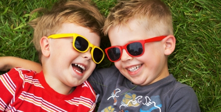 Smiling young brothers wearing fancy sunglasses