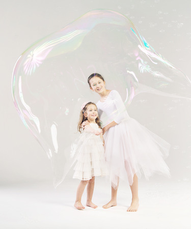 Two sisters with the large soap bubbleの写真素材