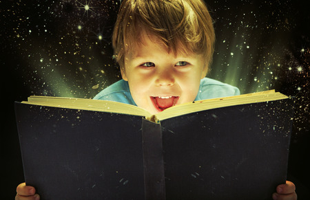Small boy carrying an old magic bookの写真素材
