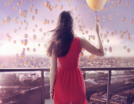 Young woman staring at thousands of the colorful balloonsの写真素材