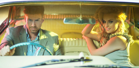 Elegant couple riding the retro carの写真素材