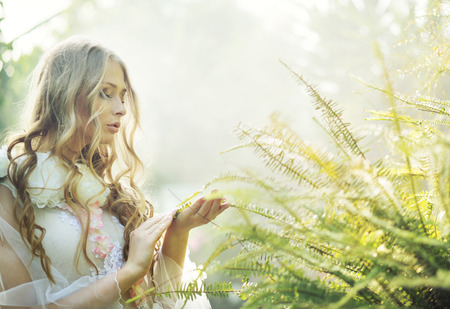 Pretty blonde woman with the green fernの写真素材