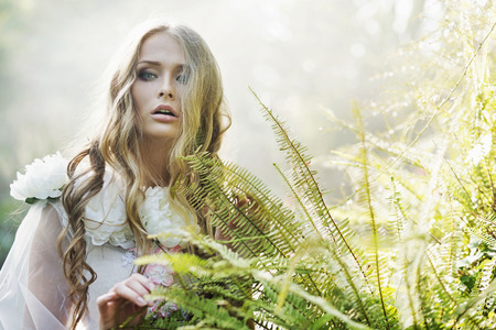 Beautiful blond woman next to the tropical fernの写真素材