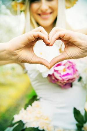 Beautiful joyful woman making the heart signの写真素材