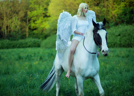Bare feet woman - angel riding a horseの写真素材