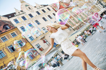 Shapely blonde catching the soap bubbles