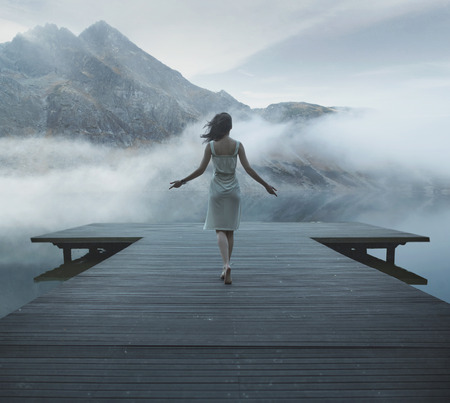 Alluring woman walking on the wooden jettyの写真素材