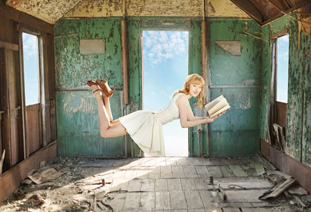 Glad levitating redhead lady with the bookの写真素材