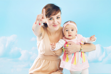 Young mom playing with her tiny daughterの写真素材