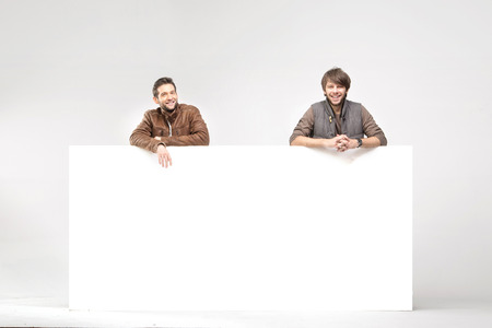 Two smiling guys with huge billboardの写真素材