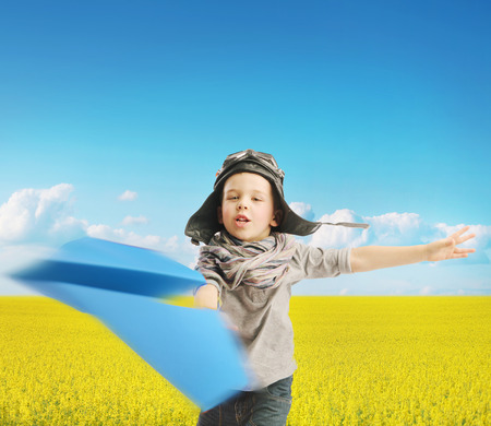 Little boy playing the blue paper planeの写真素材