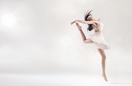 Pretty female ballet dancer in hard jump figureの写真素材