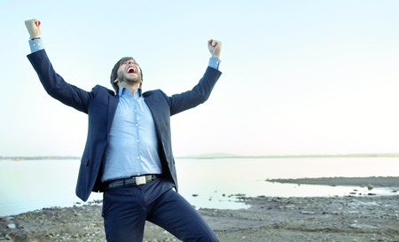 Young handsome businessman on the stone beachの写真素材