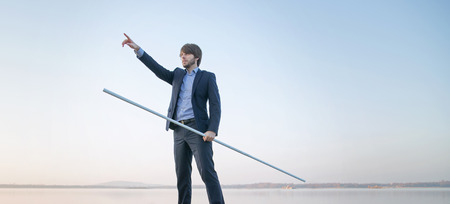 Handsome businessman holding long stickの写真素材