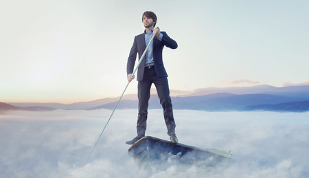 Handsome businessman rowing in the boatの写真素材