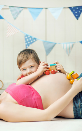 Cute little boy playing with the unborn sibling