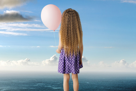 Conceptual photo of a little girl with a balloonの写真素材