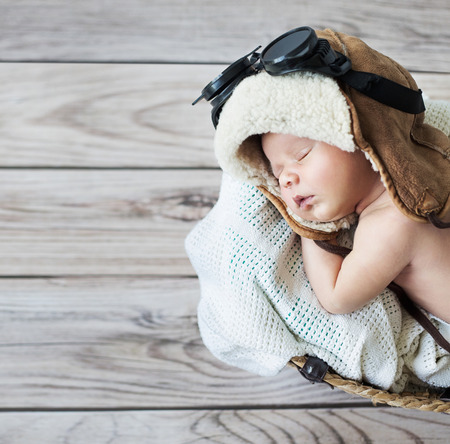 Cute little boy sleeping with pilot goggles