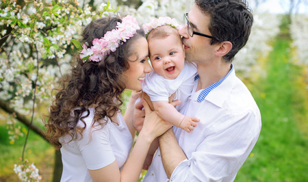Cheerful parents kissing their beloved babyの写真素材