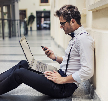 Busy elegant businessman working in the lobbyの写真素材