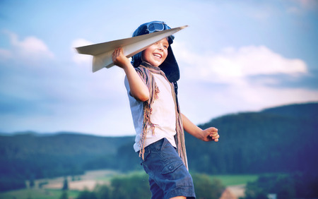 Cheerful little boy toy paper planeの写真素材