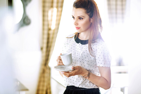 Pretty young woman drinking coffeeの写真素材