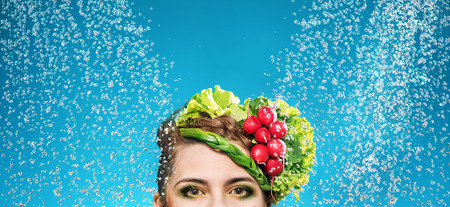 Portrait of a woman with vegetables on headの写真素材
