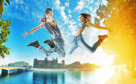 Two cheerful jumping dancers on an urban backgroundの写真素材
