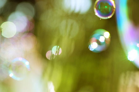 Image of shiny soap bubbles over the green backgroundの写真素材
