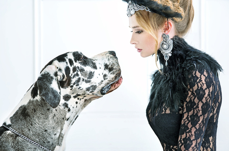 Elegant young woman staring at the friendly dogの写真素材