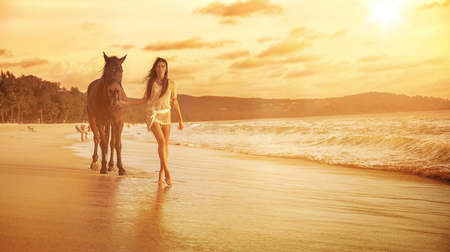 Charming brunette lady walkig with her loyal horse companionの写真素材