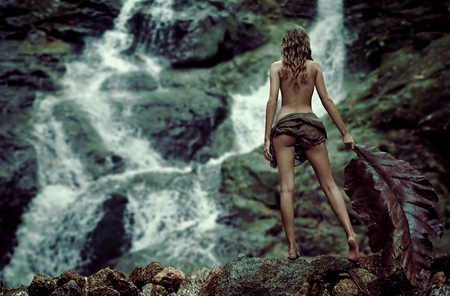 Pretty young woman at the tropical waterfallsの写真素材