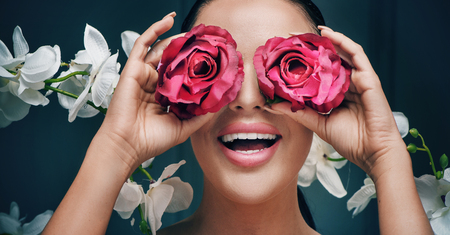 Portrait of an elegant woman holding red rosesの写真素材