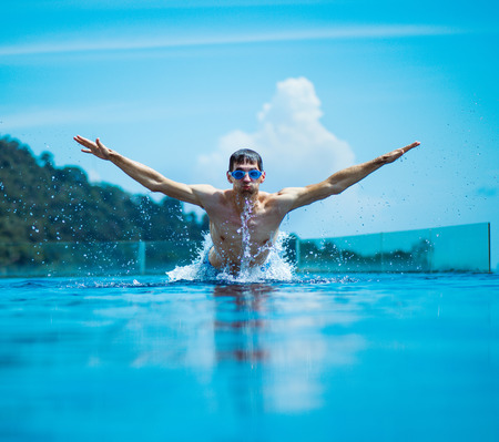 Young, muscular swimmer splashing water - summer shotの写真素材