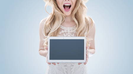Pretty blond lady holding a tabletの写真素材