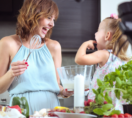 Mother and daughter preparing a tasty summer breakfast togetherの写真素材