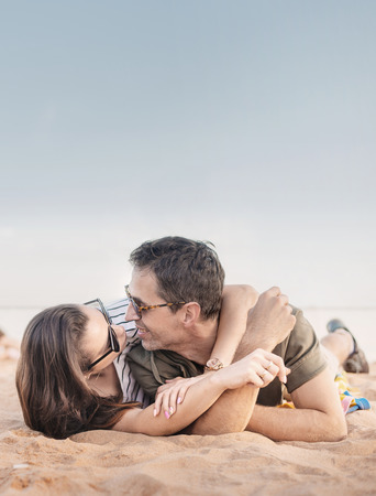Portrait of a romantic, young couple relaxing on a beachの写真素材