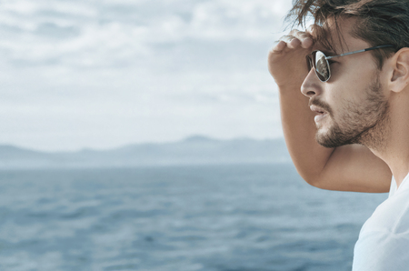 Profile portrait of a handsome guy relaxing on the boatの写真素材