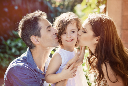Happy parents kissing their beloved daughterの写真素材