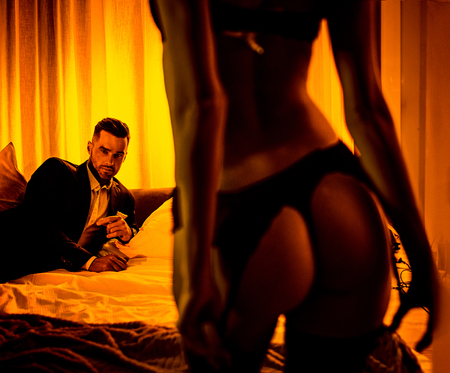Sensual woman taking off her clothes in front of a loverの写真素材