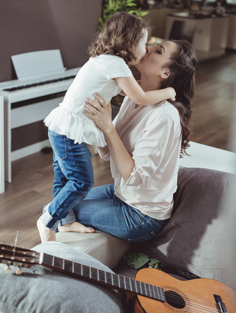 Happy mother with a little daughter at homeの写真素材