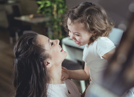 Happy mother with a little daughter at homeの写真素材