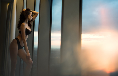 Brunette, sensual woman on a top of the skysrcyperの写真素材