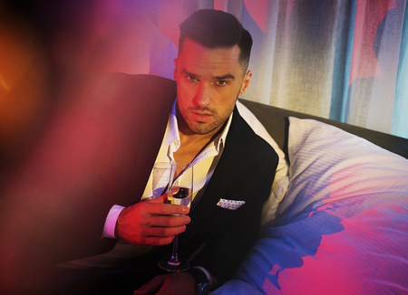Handsome guy drinking champagne - party shotの写真素材