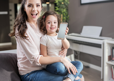 Happy mother with a cute daughter at homeの写真素材