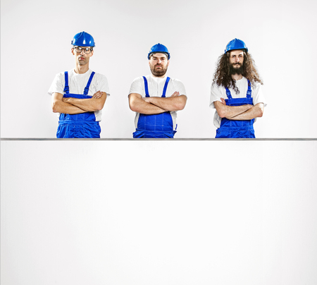 Three talented craftsmen with an empty, white boardの写真素材