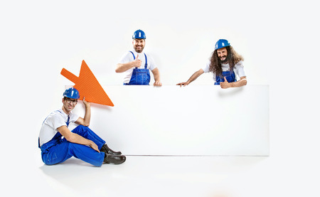 Three crfatsmen and the huge commercial, empty board