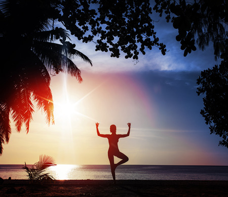 Flexible woman training on a tropical beachの写真素材