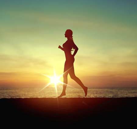 Calm, pretty woman running on the tropical beachの写真素材